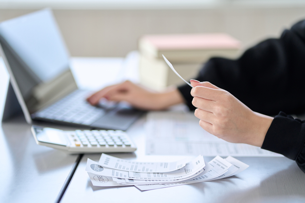 Asian woman entering expenses in accounting software